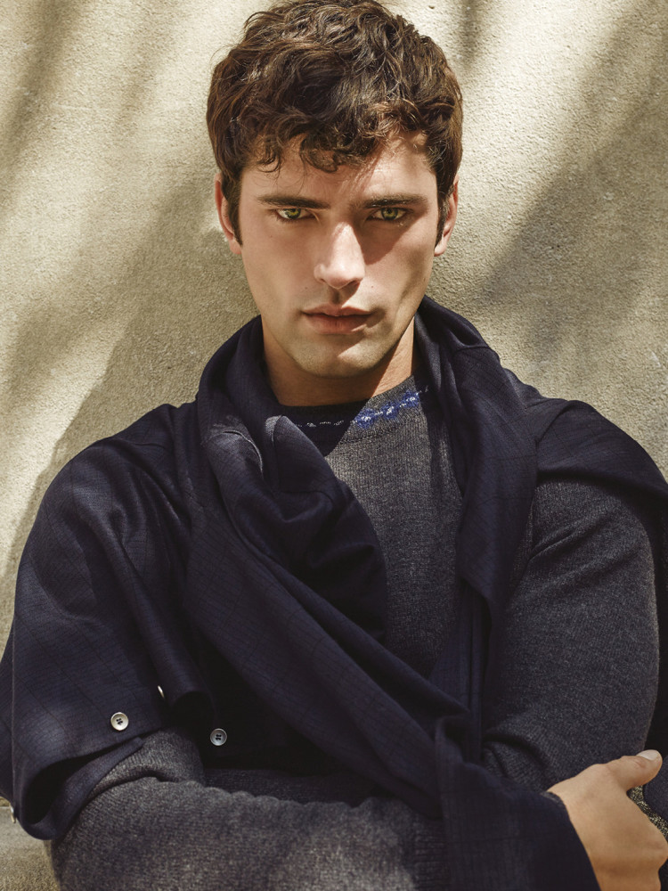 Sean O’Pry in a dark jacket, photographed against a textured wall